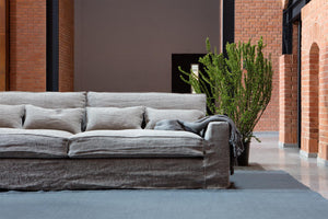 Grey linen deep wide 4 seater sofa in red brick building